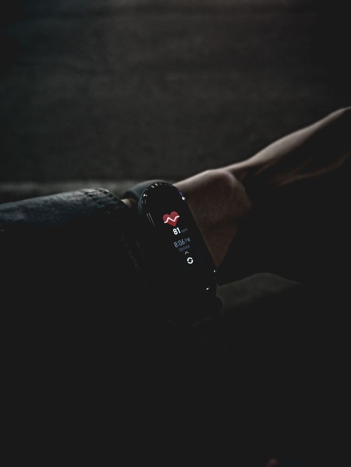 fitness tracker on wrist displaying vital signs