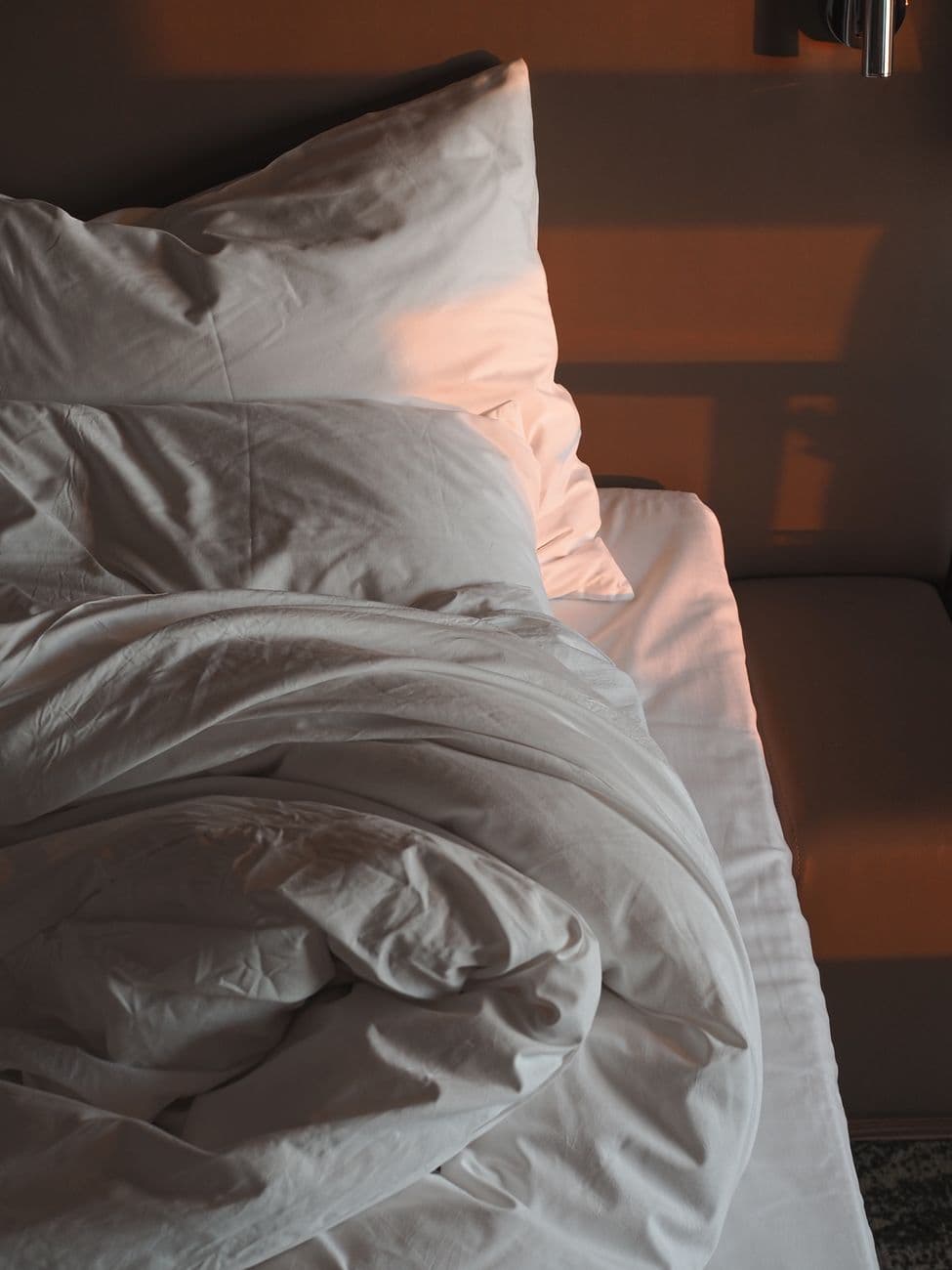 cooling mattress pad on a bed with white bedding in a bright bedroom